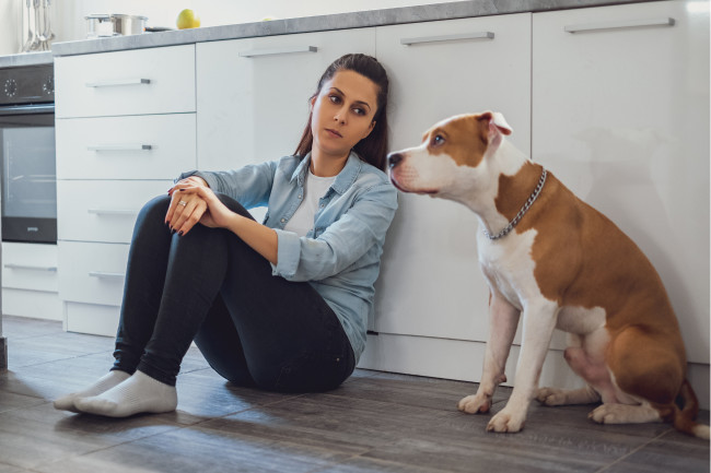 Woman and dog sitting in kitchen