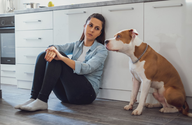 Woman and dog sitting in kitchen