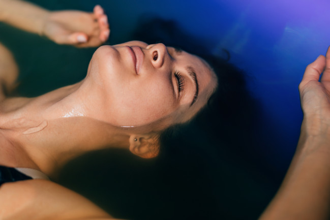 Woman floating in a therapeutic tank for sensory deprivation. 