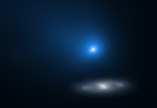 The real deal: Comet Borisov, an interstellar visitor imaged by the Hubble Space Telescope in 2019 as it passed in front of a distant spiral galaxy. (Credit: NASA/ESA/D. Jewitt-UCLA)