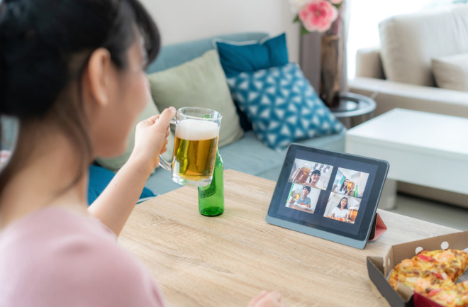 woman pandemic virtual happy hour drinking a beer - shutterstock