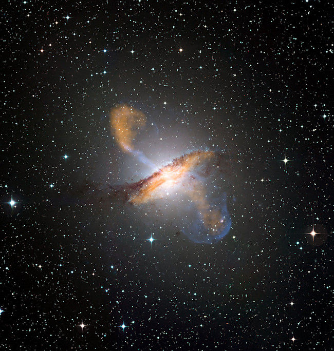 This image of Centaurus A, an active galactic nucleus ejecting material from its center, combines X-ray, microwave, and visible light images. (Credit: ESO/WFI (visible); MPIfR/ESO/APEX/A.Weiss et al. (microwave); NASA/CXC/CfA/R.Kraft et al. (X-ray))