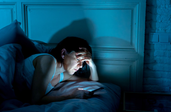 Woman awake late at night looking at smart phone
