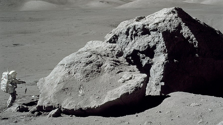 Apollo 17 astronaut Harrison H. Schmitt standing beside a boulder on the lunar surface. (Credit: NASA)