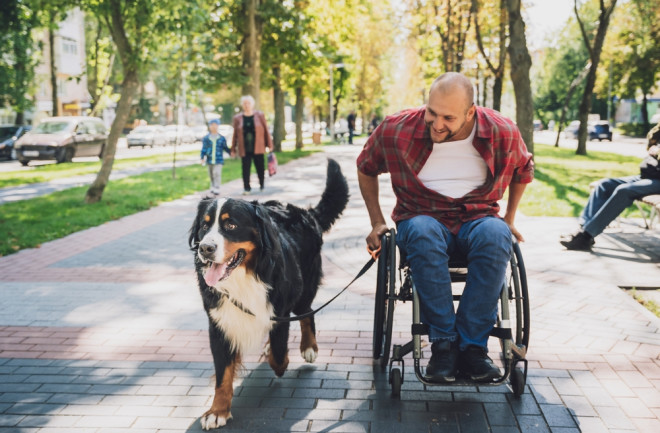 Man with a physical disability who uses wheelchair with his dog.