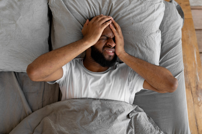 Man with headache in bed