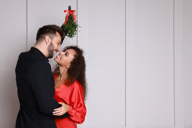 Festive couple kissing under the mistletoe