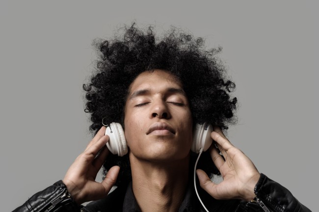 Man listening to music on headphones - Shutterstock