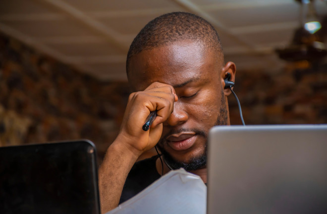 Sitting at a desk work from home drained - shutterstock