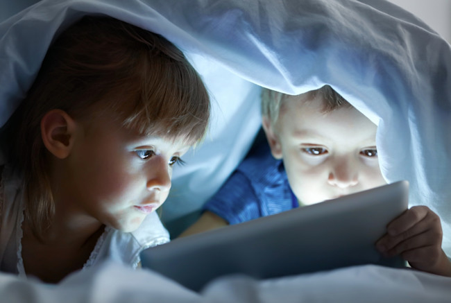 Kids on Phone Tablet Bed - Shutterstock