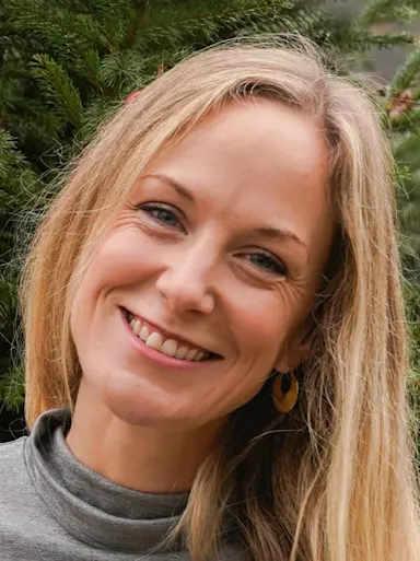 A woman with blonde hair smiling at the camera.