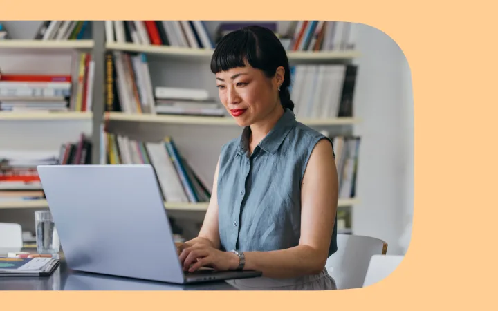 Woman sits at laptop comparing Typeform to Google Forms.