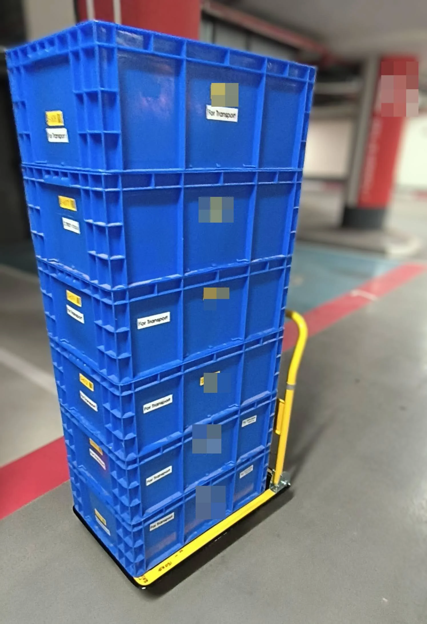 Six boxes on a hand truck in the car park — the load that would otherwise be six separate carries.