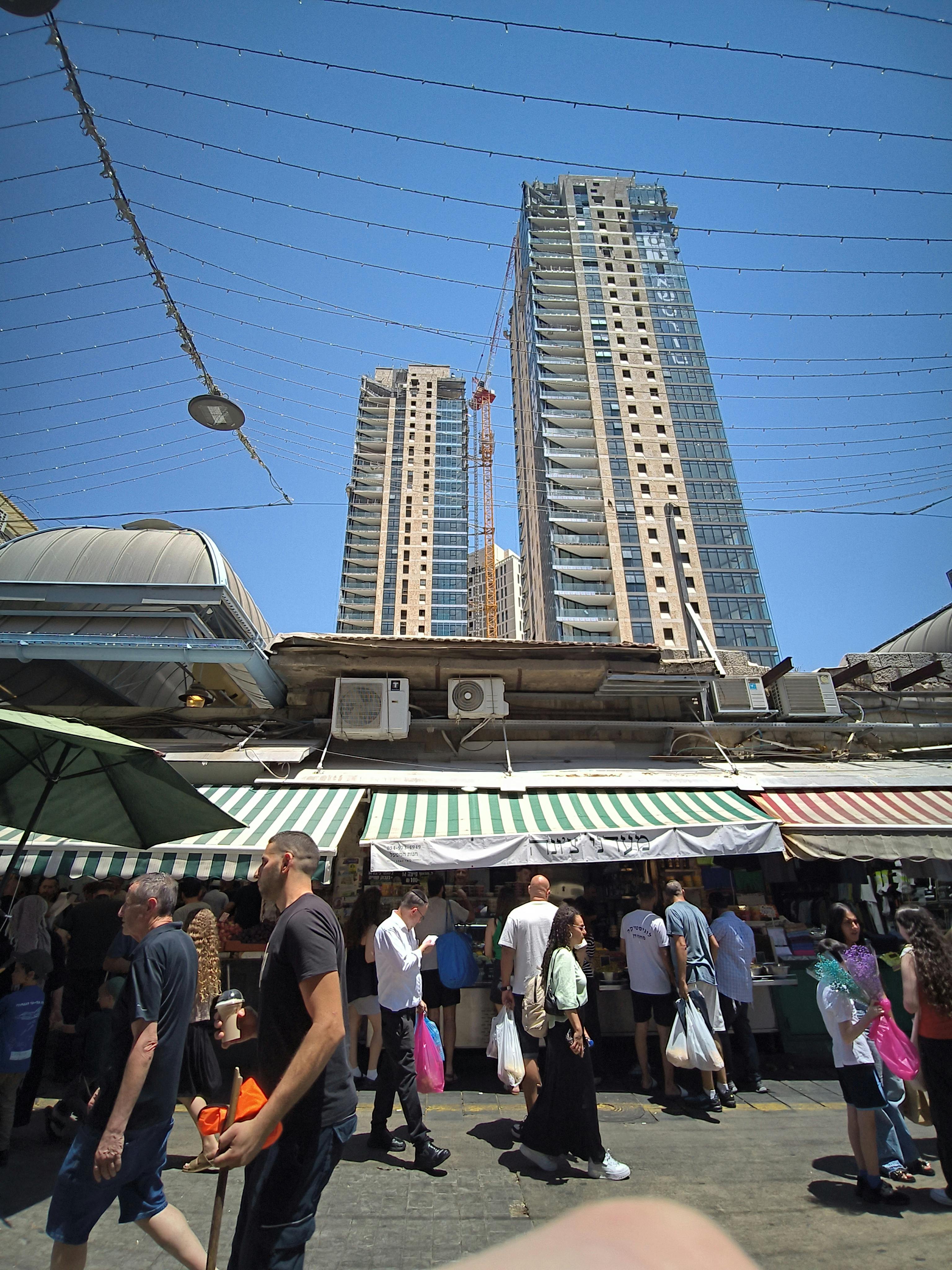 New high rises tower over the 'bastas' - or stalls - of the Mahane Yehuda market. Photo: author.