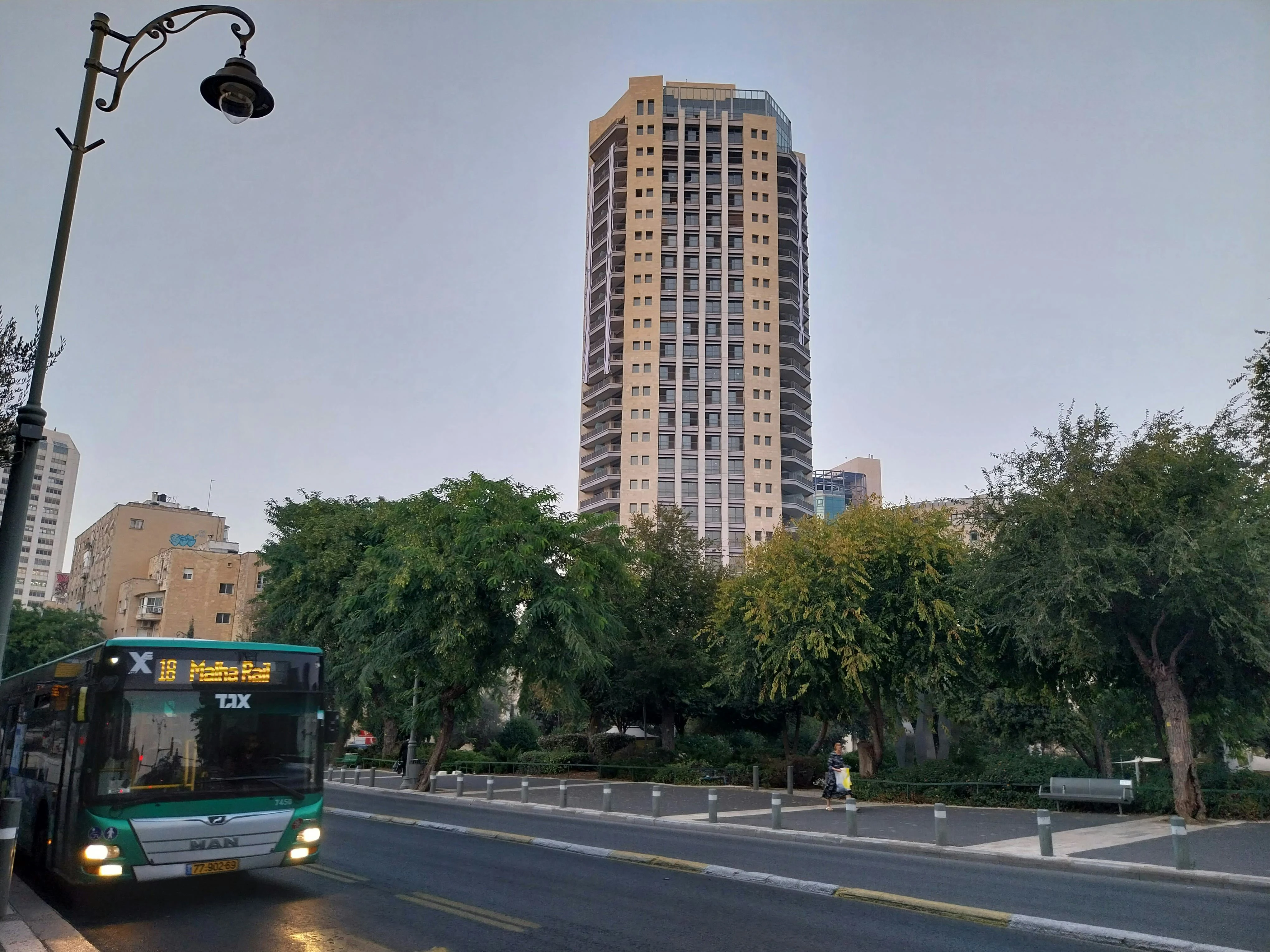 A bus operated by the Superbus company stops at a bus stop. In the background, another high rise looms. Photo: author.