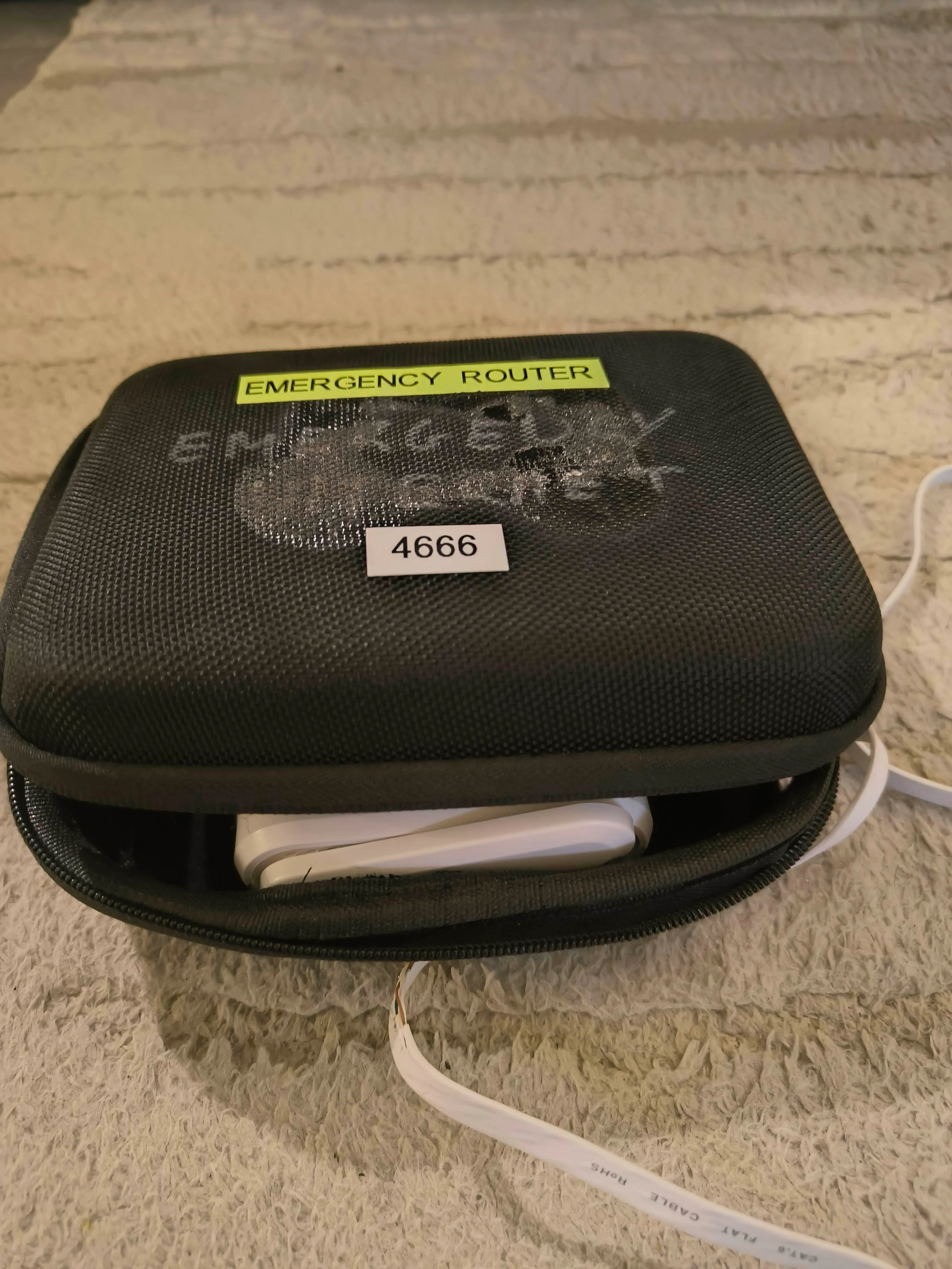 Photo of the carry case closed with Emergency Router label visible