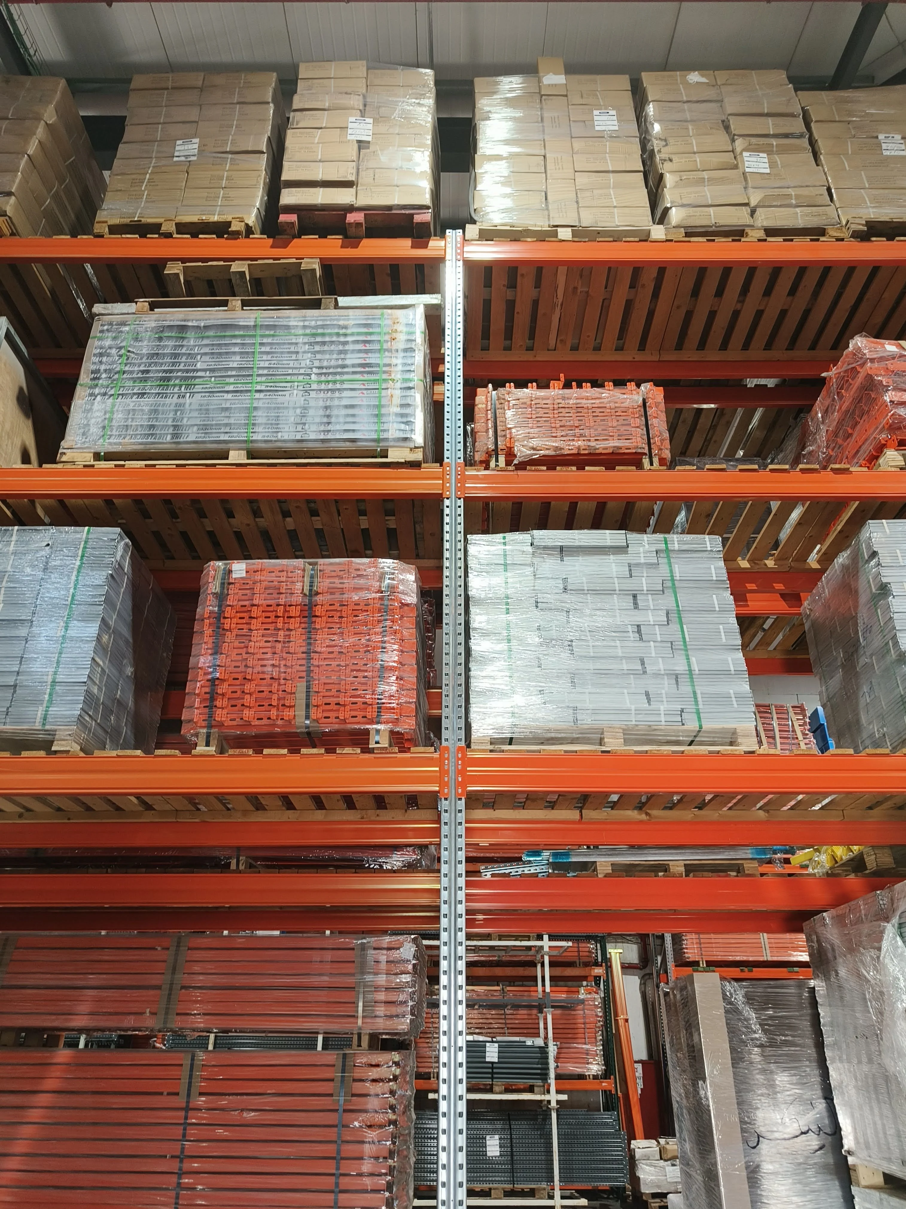 Beams, uprights and steel decking racked up at the shelving supplier — the same pallet-racking components scaled down to a flat.