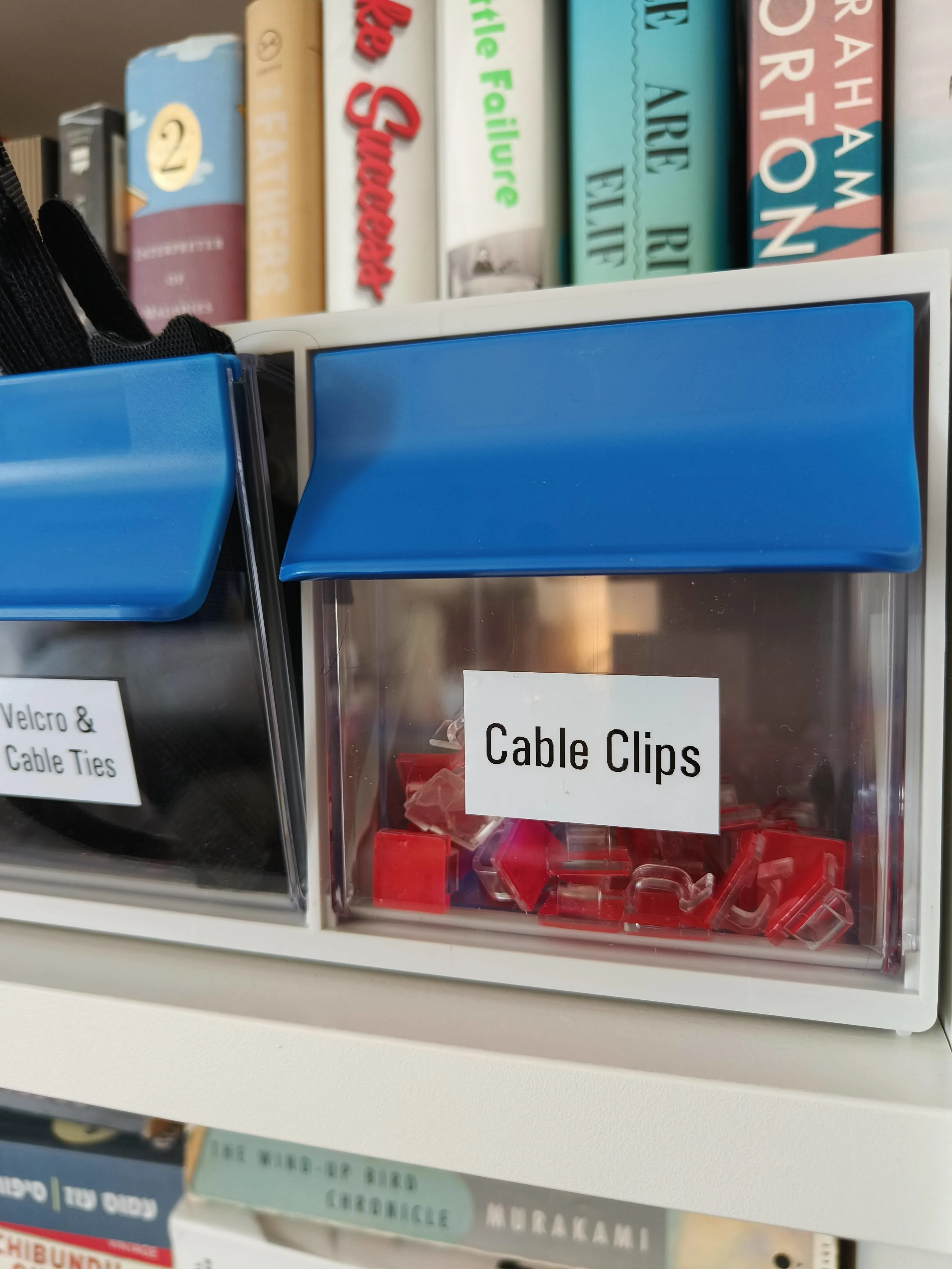 A size-3 picking bin on the shelf face: cable clips, labelled, open-front, no lid to lift.