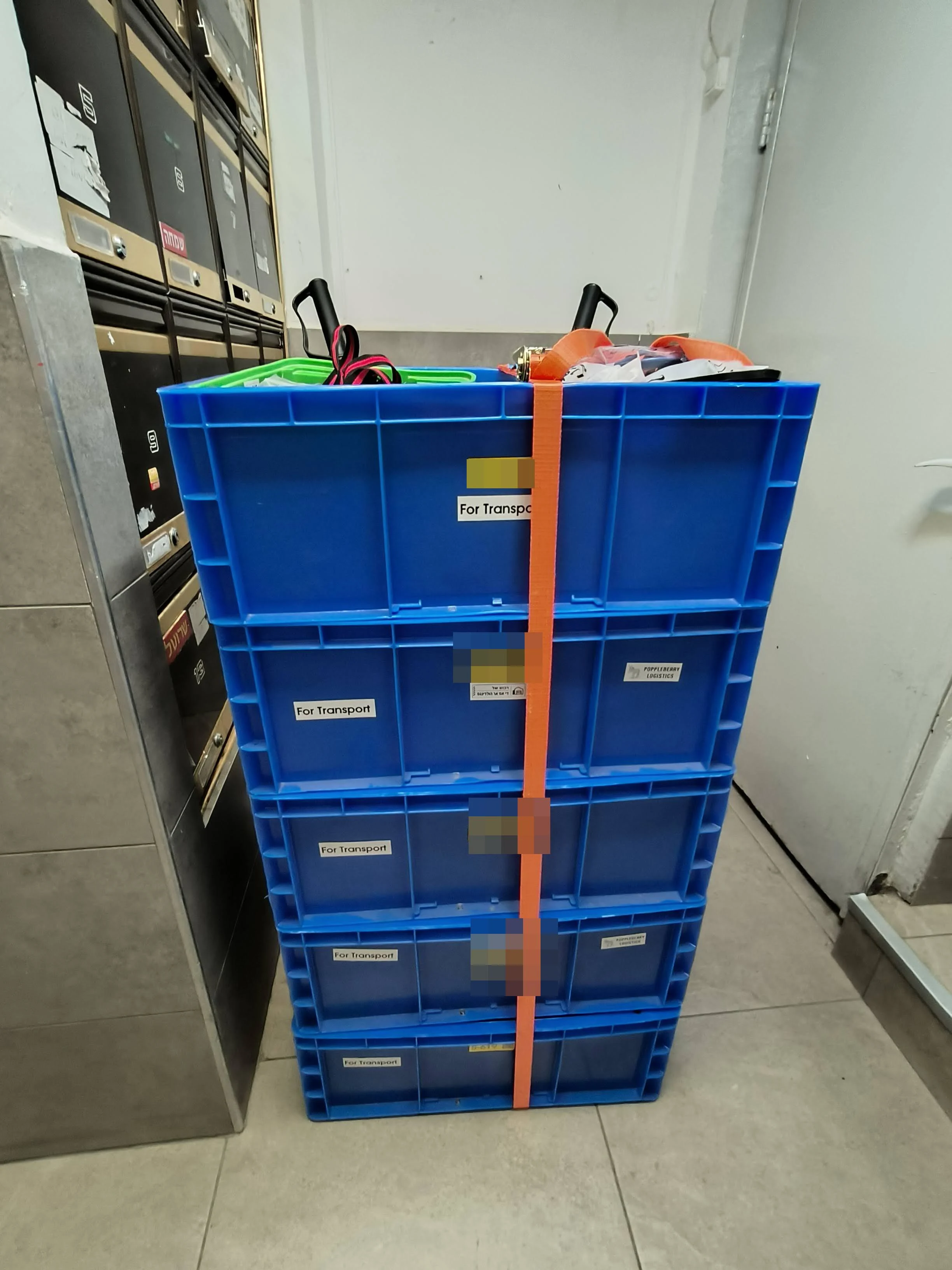 Five boxes ratchet-strapped into one unit, waiting for the service lift.