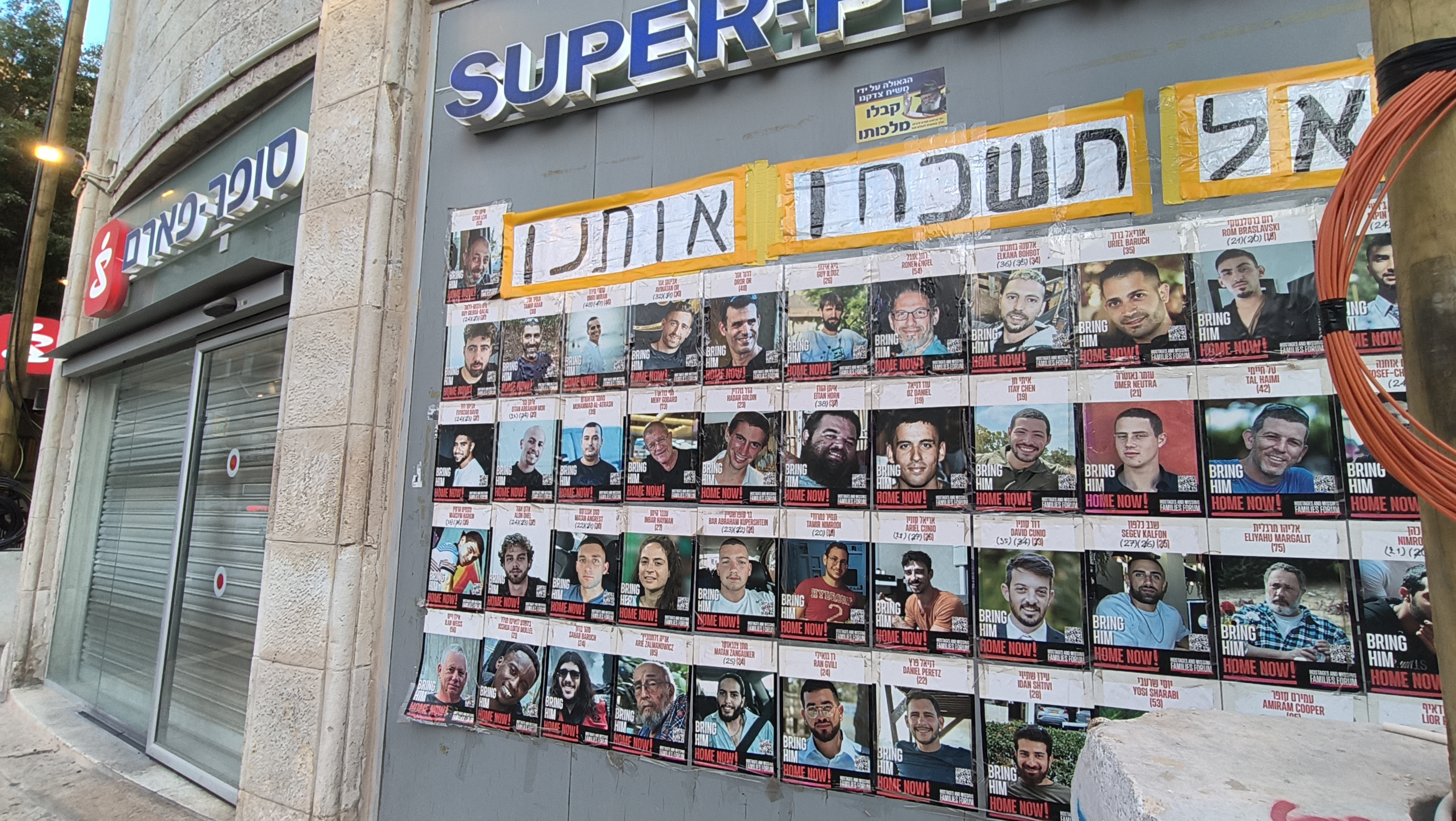 A hostage poster outside a branch of the Israeli pharmacy chain Super Pharm. The Hebrew above the individual posters reads