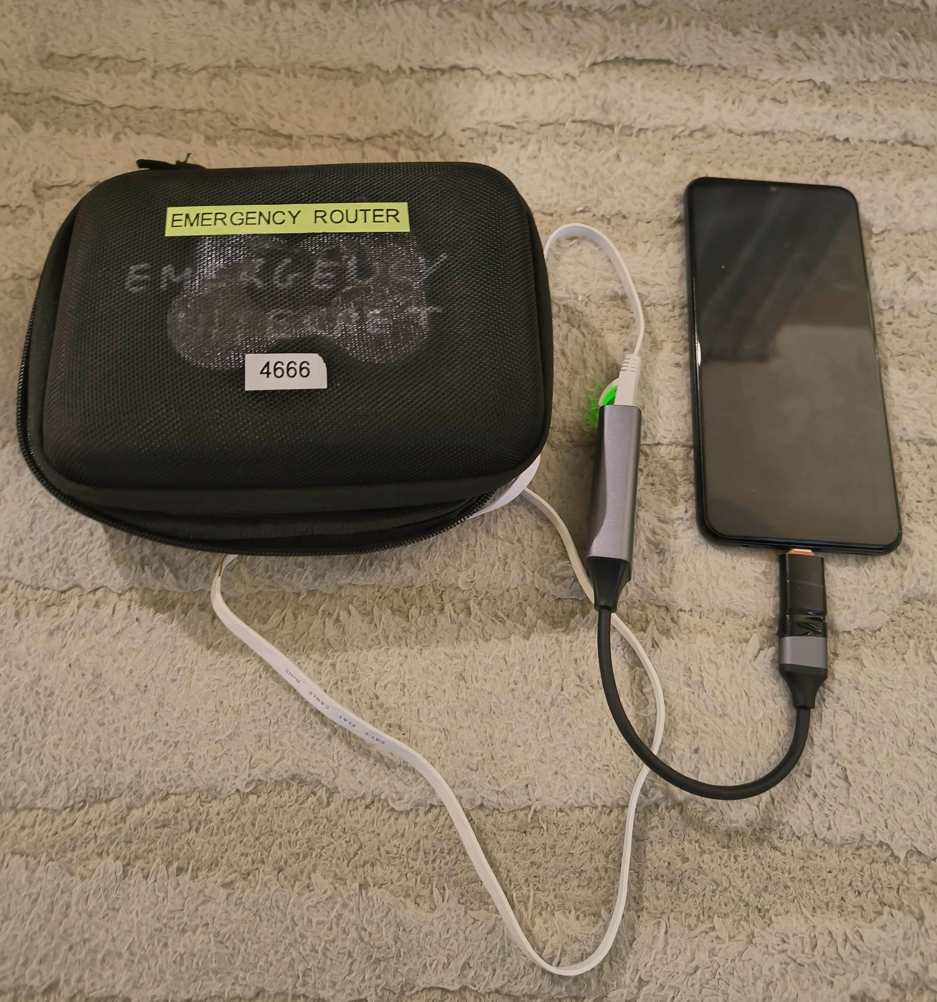 Photo showing the Emergency Router case connected to Android phone via ethernet adapter