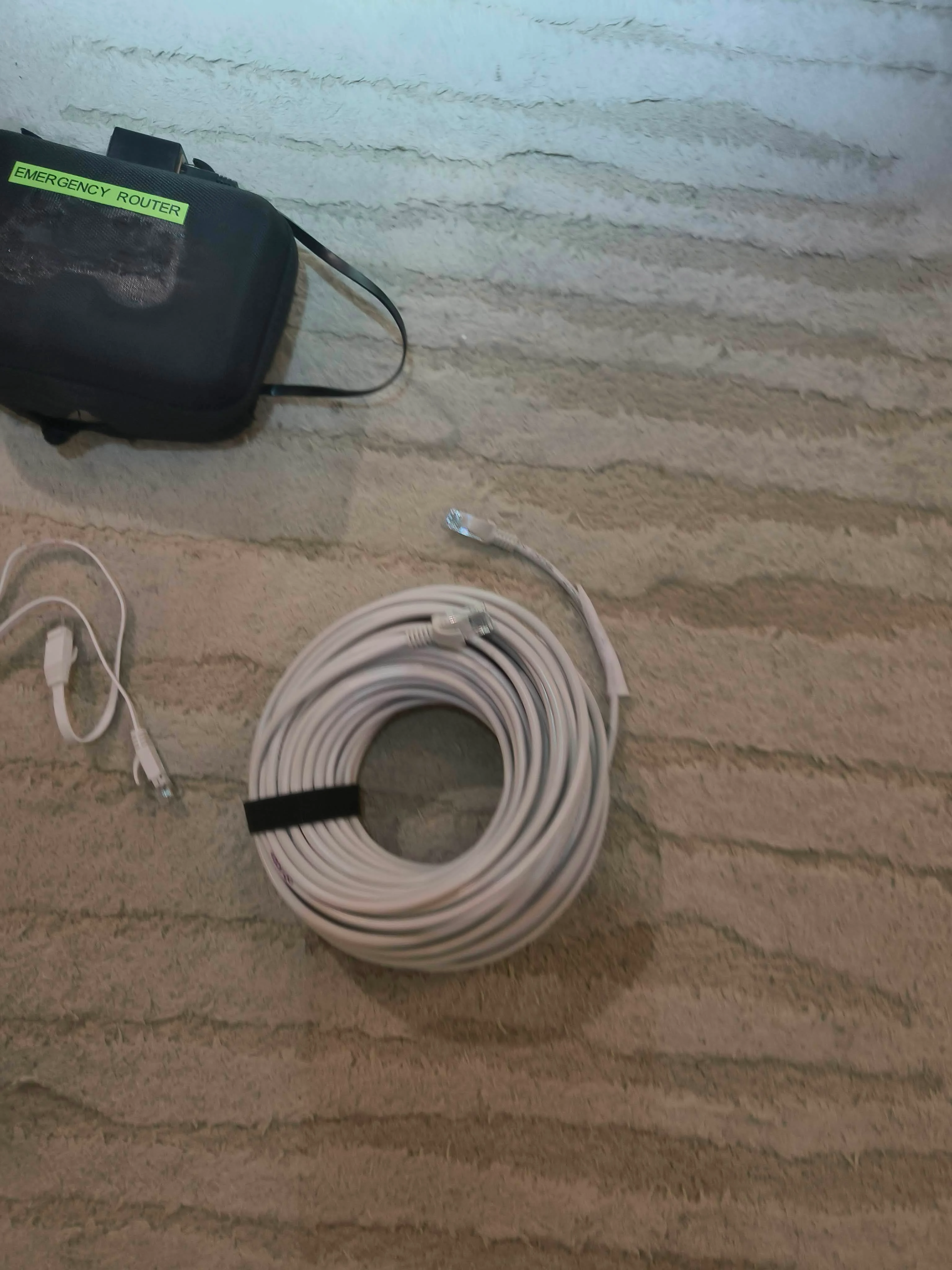 Photo showing the full kit with 20-meter ethernet cable coiled alongside the carry case
