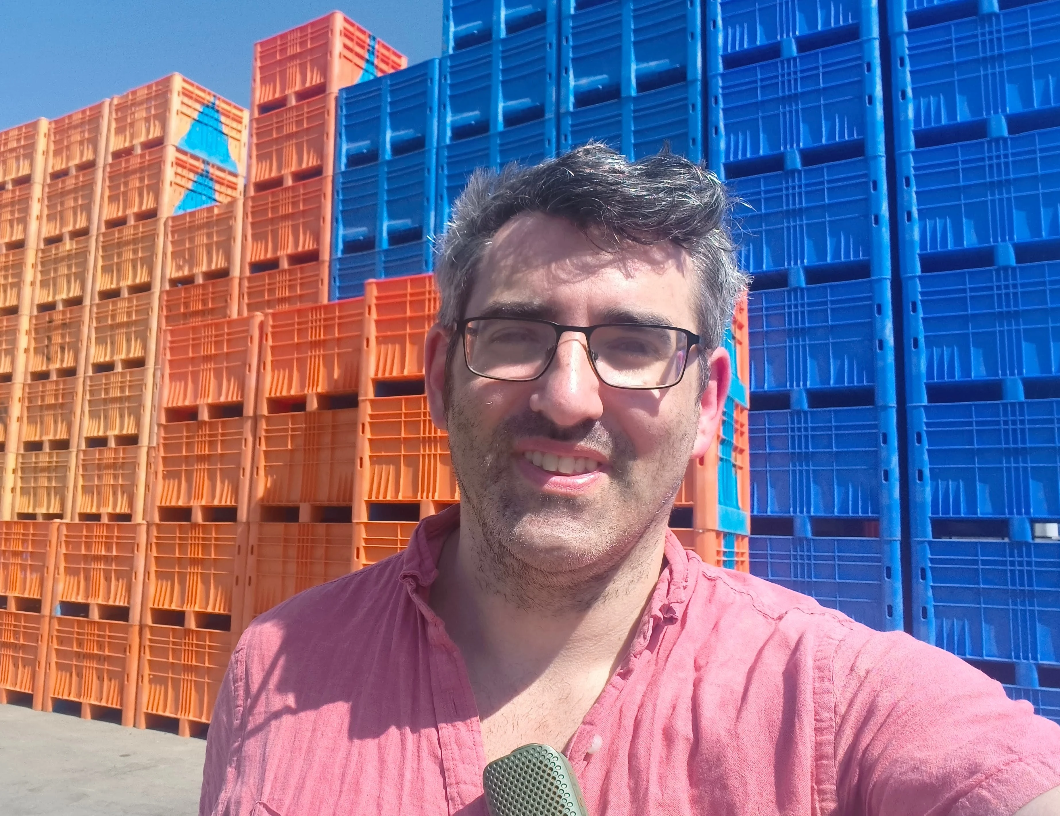 The author standing in front of stacked Euro containers at YosiBox, near Ashdod.