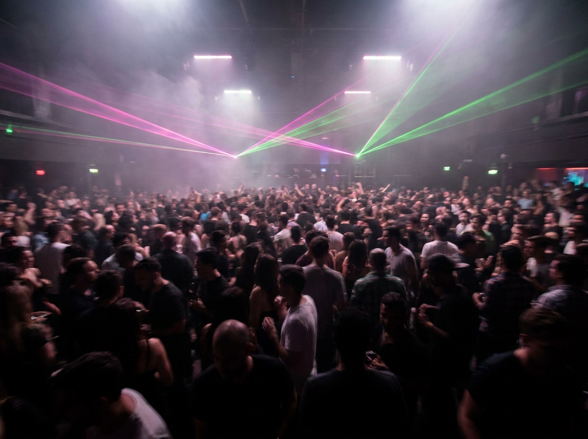 A packed dance floor at a nightclub during a high-energy DJ event.