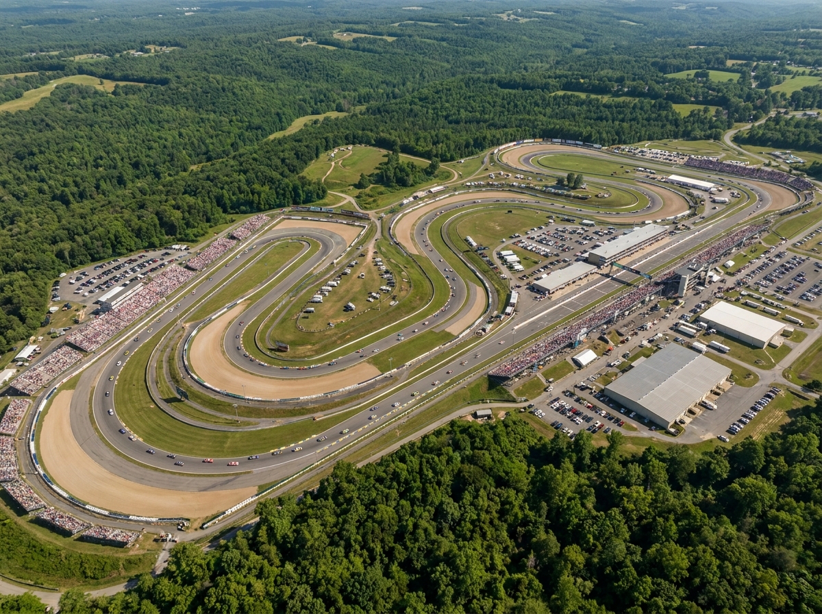 An aerial view of a large motorsport event, showing the full race track and surrounding facilities.
