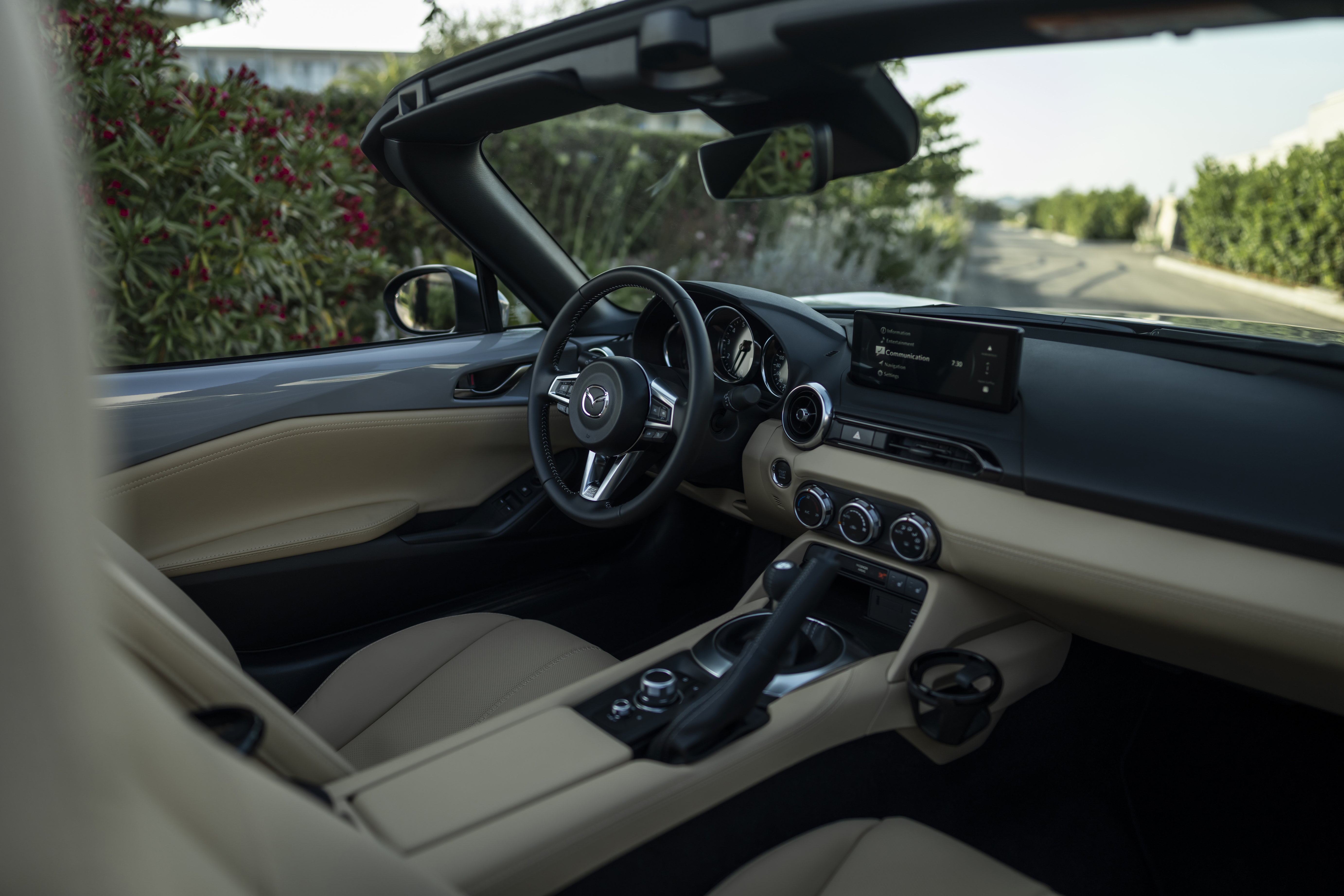Source: https://de.mazda-press.com/cars/mazda-mx-5/ — press image, editorial use. Shot in the MX-5 Roadster; the RF shares an identical dashboard and no soft-top is visible in frame. Approved by operator 2026-09-18. Run: 2026-09-18