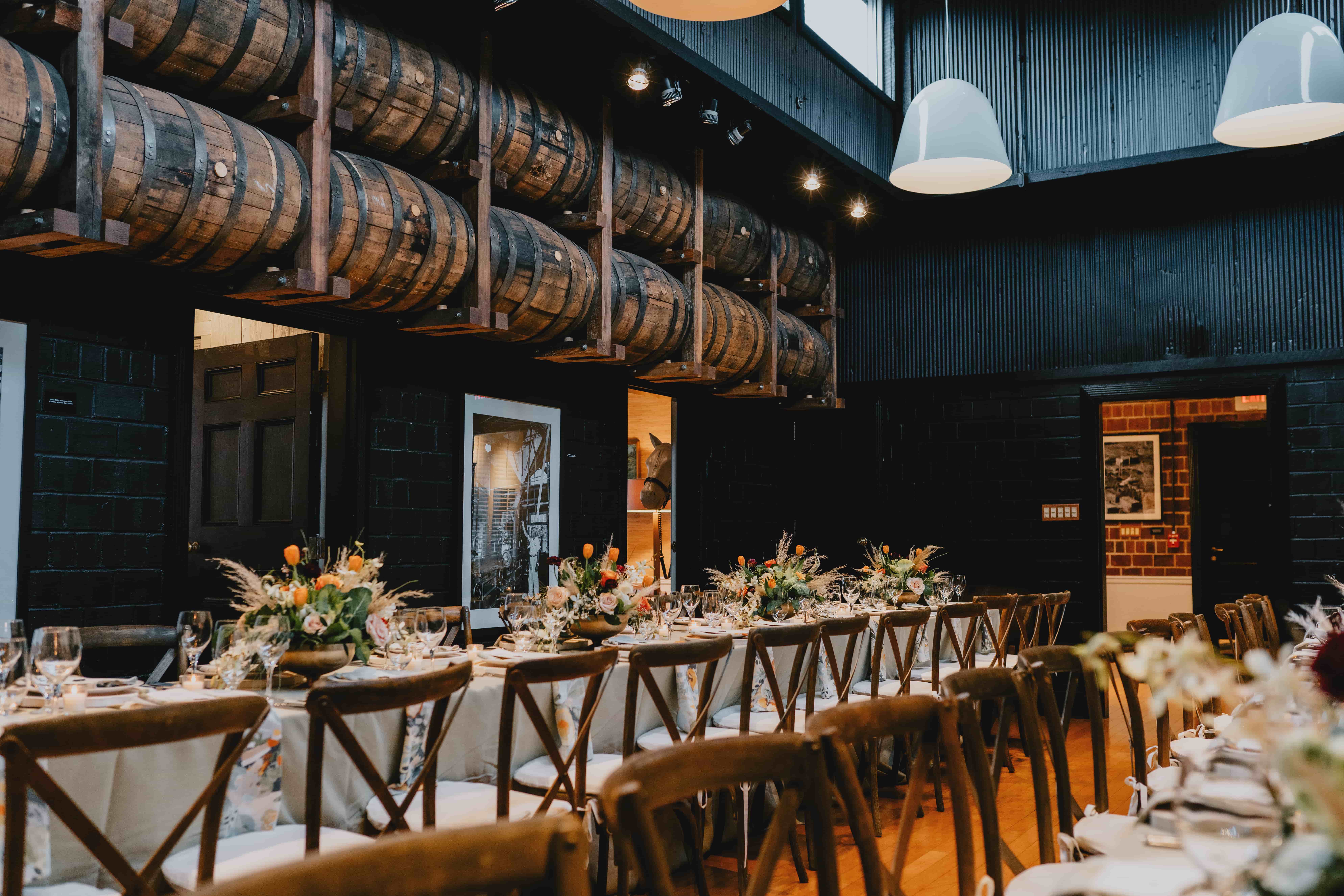 A beautifully set dining room features a long table adorned with floral centerpieces and elegant tableware.