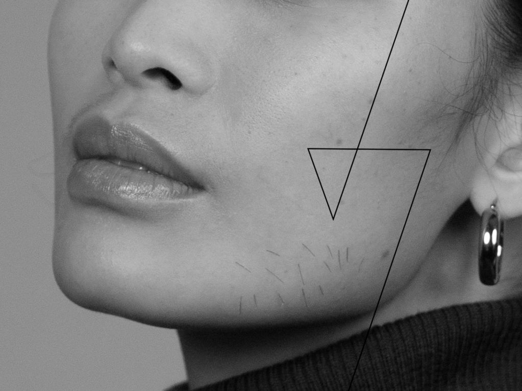 Woman's face with facial hair on her cheek