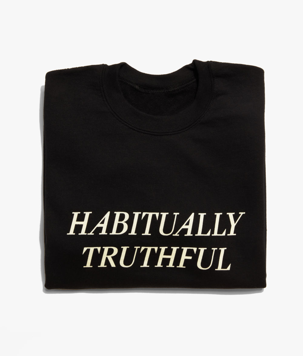 Folded Habitually Truthful pullover in black with cream lettering
