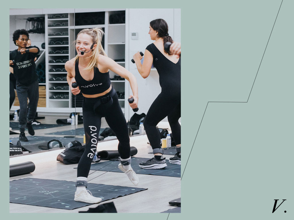 P.volve's lead trainer holding weights while teaching a fitness class 