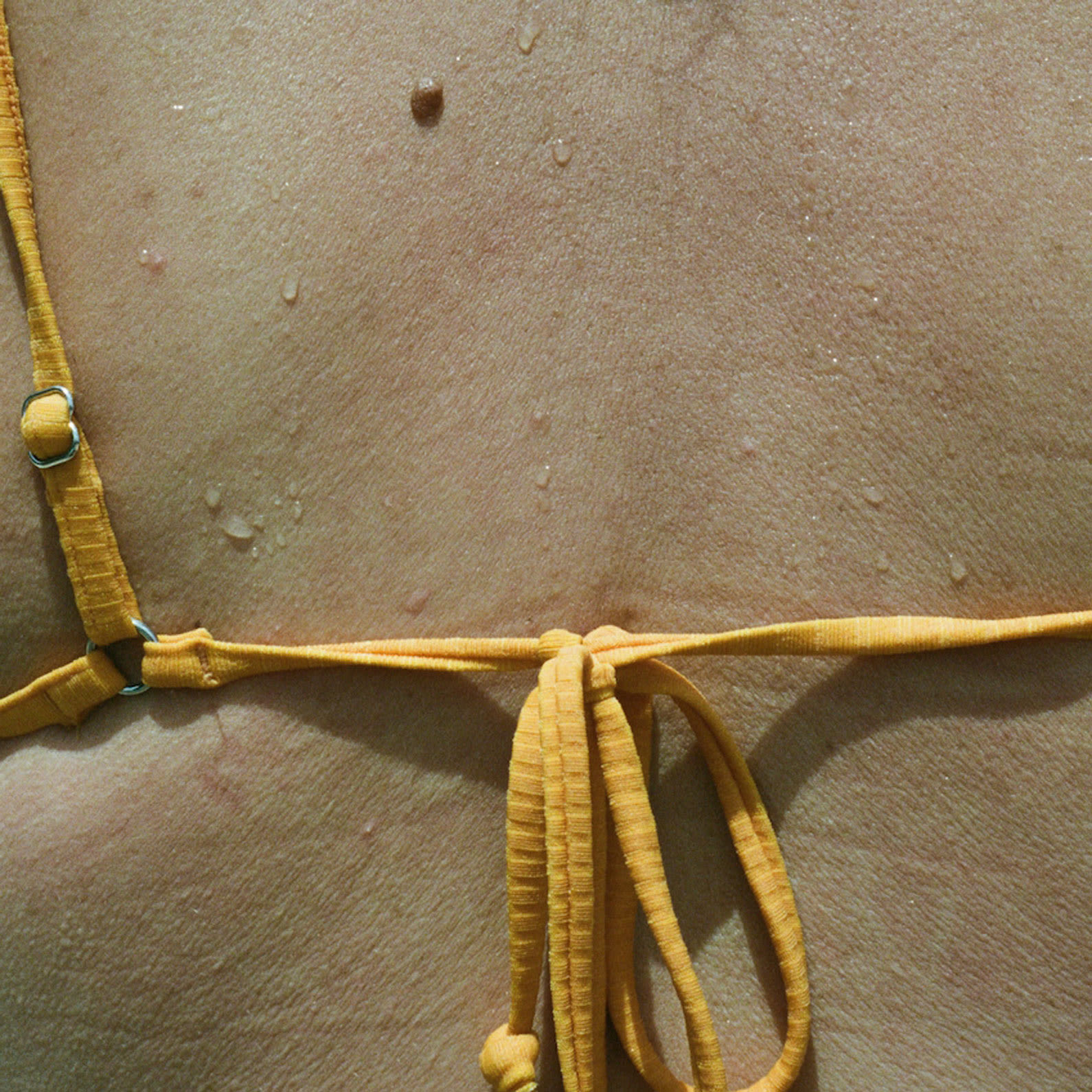 back of woman in yellow bikini