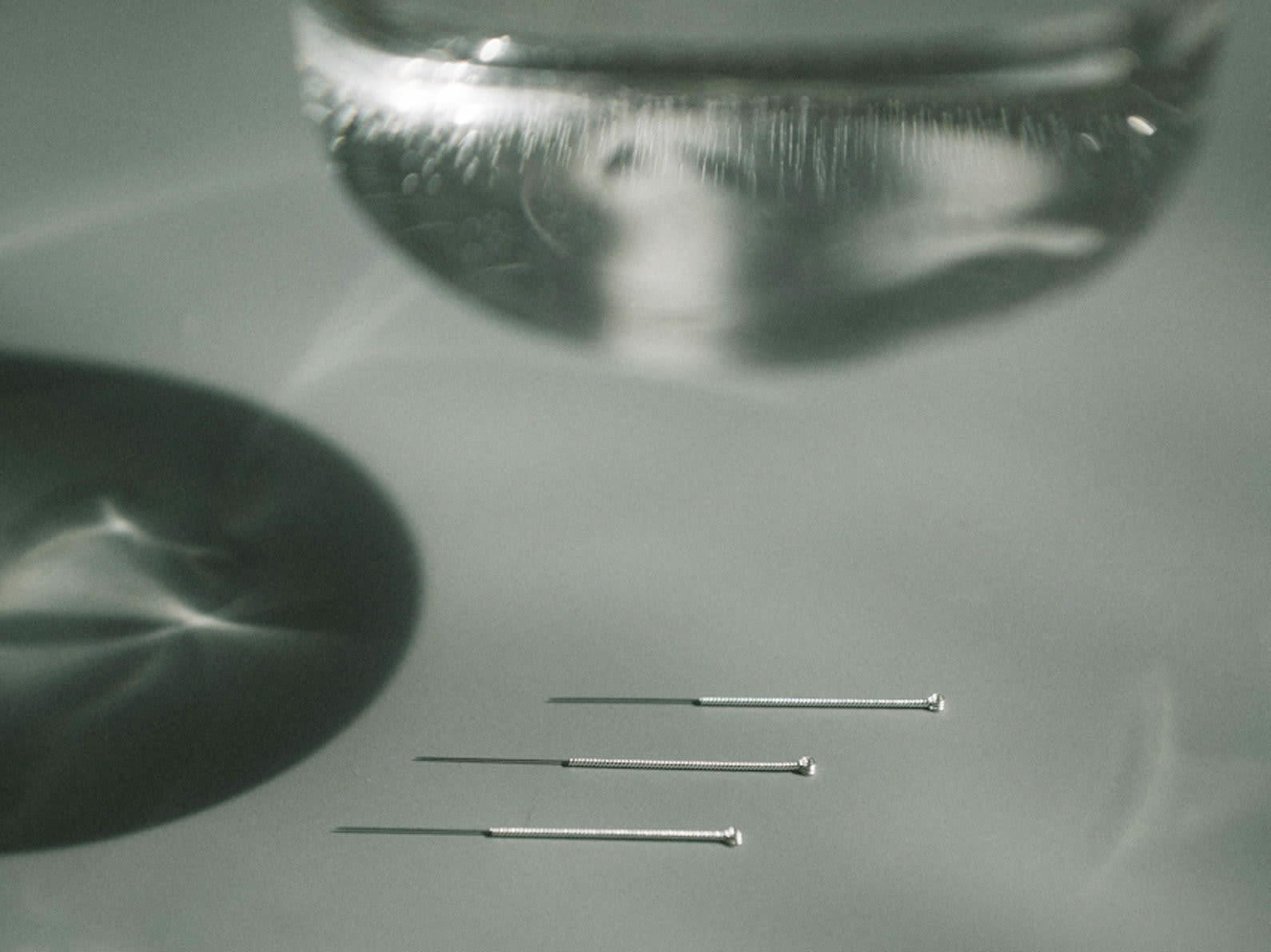 Acupuncture needles and a glass of water