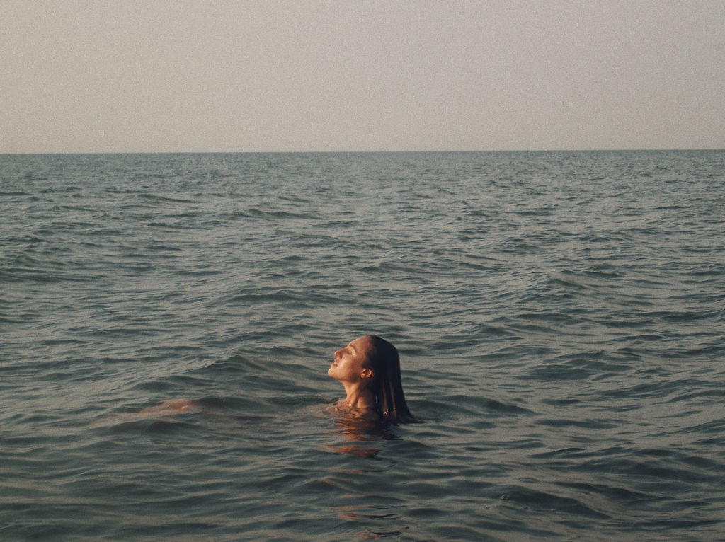 Woman's head in profile swimming in the ocean.