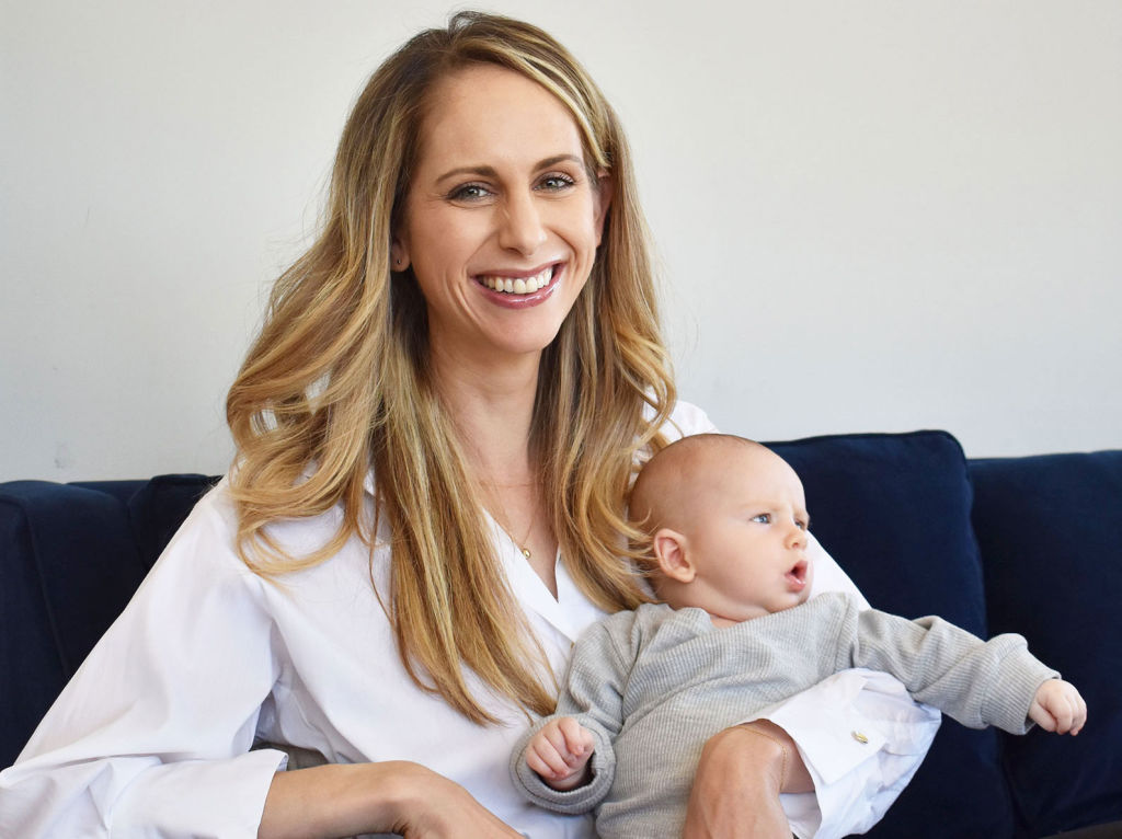 Veracity founder, Allie Egan, smiling with her newborn son