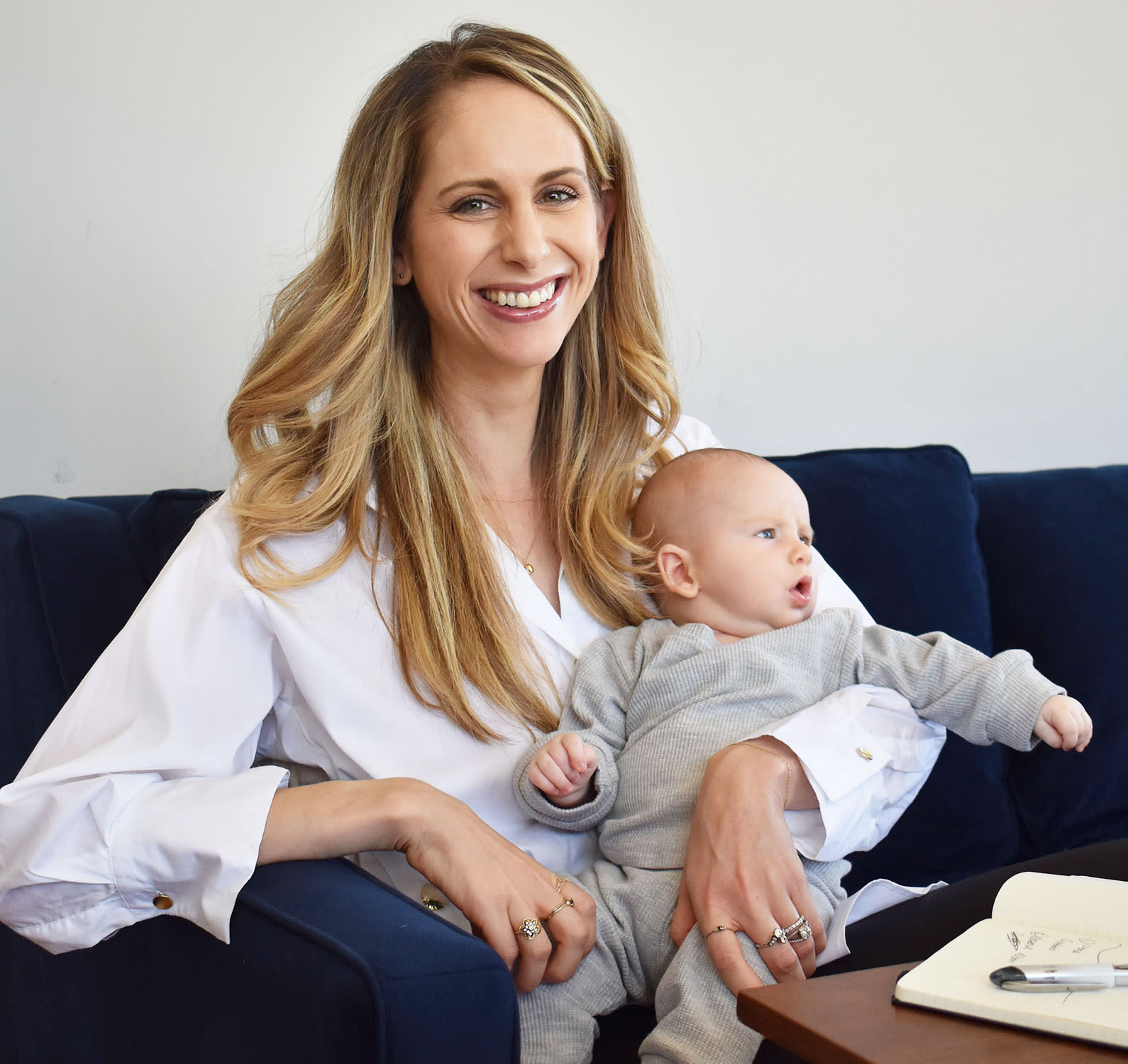 Veracity founder, Allie Egan, smiling with her newborn son in her lap.