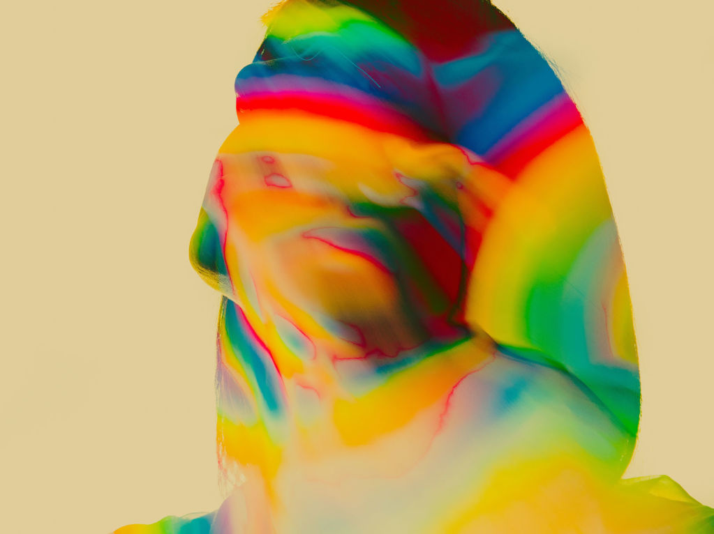 Woman's head and torso awash with rainbow colors alluding to mental state