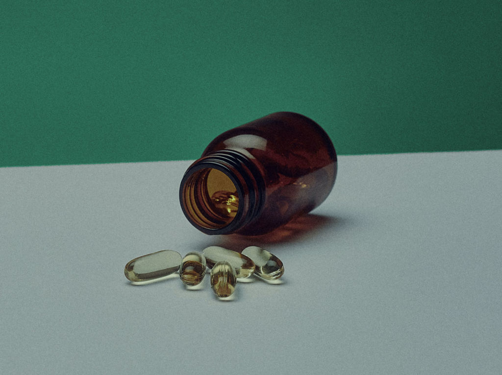 Supplement pills spilling out of a bottle 