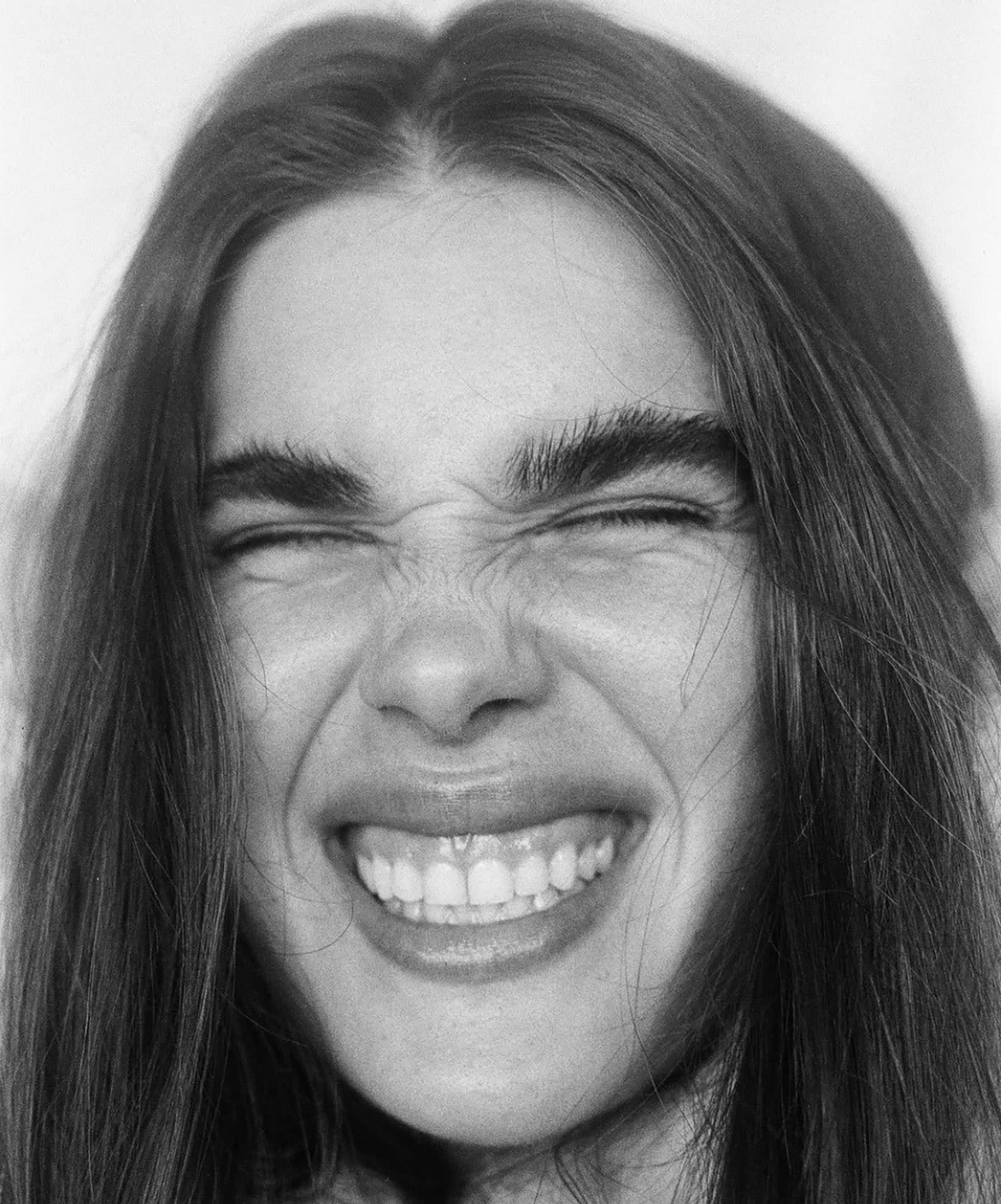 Girl scrunching her face in a black and white photograph.