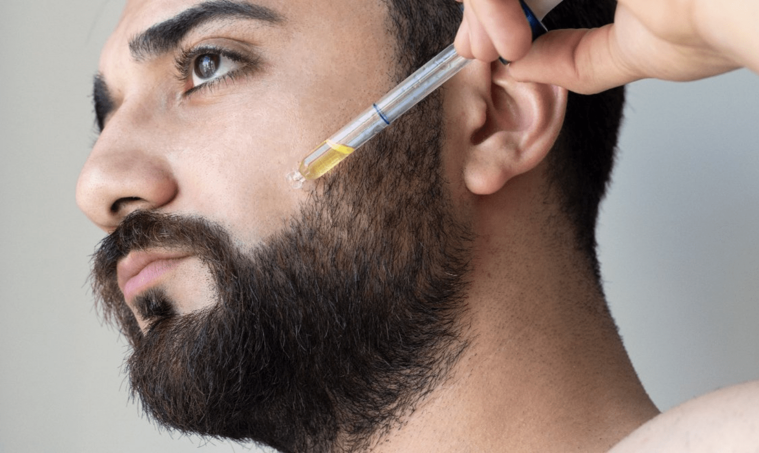 Hombre aplicándose aceite para la barba