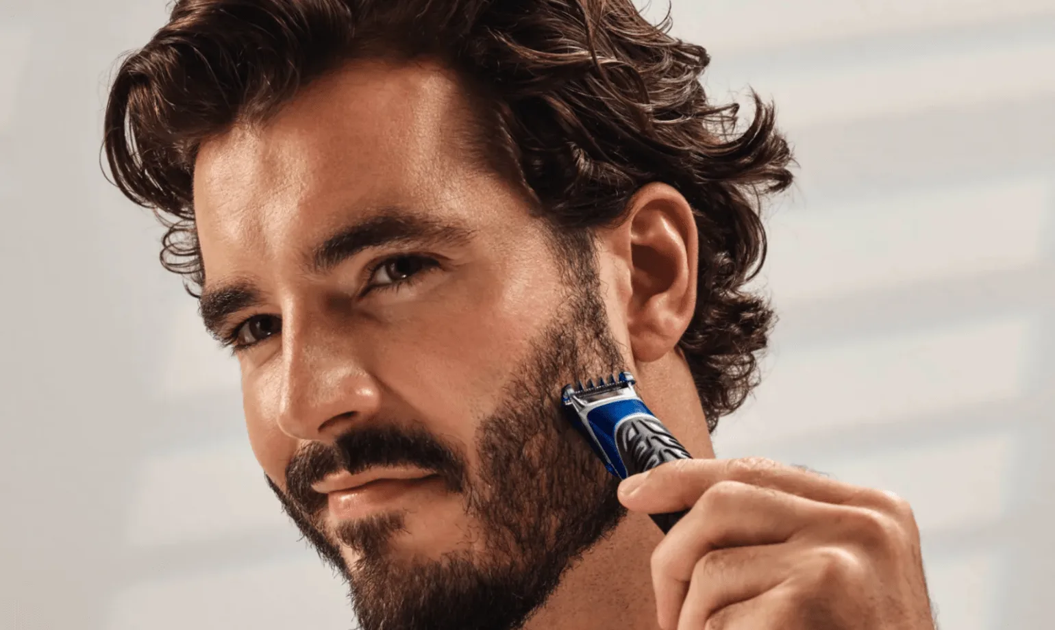 Un hombre cortándose la barba con Gillette Styler