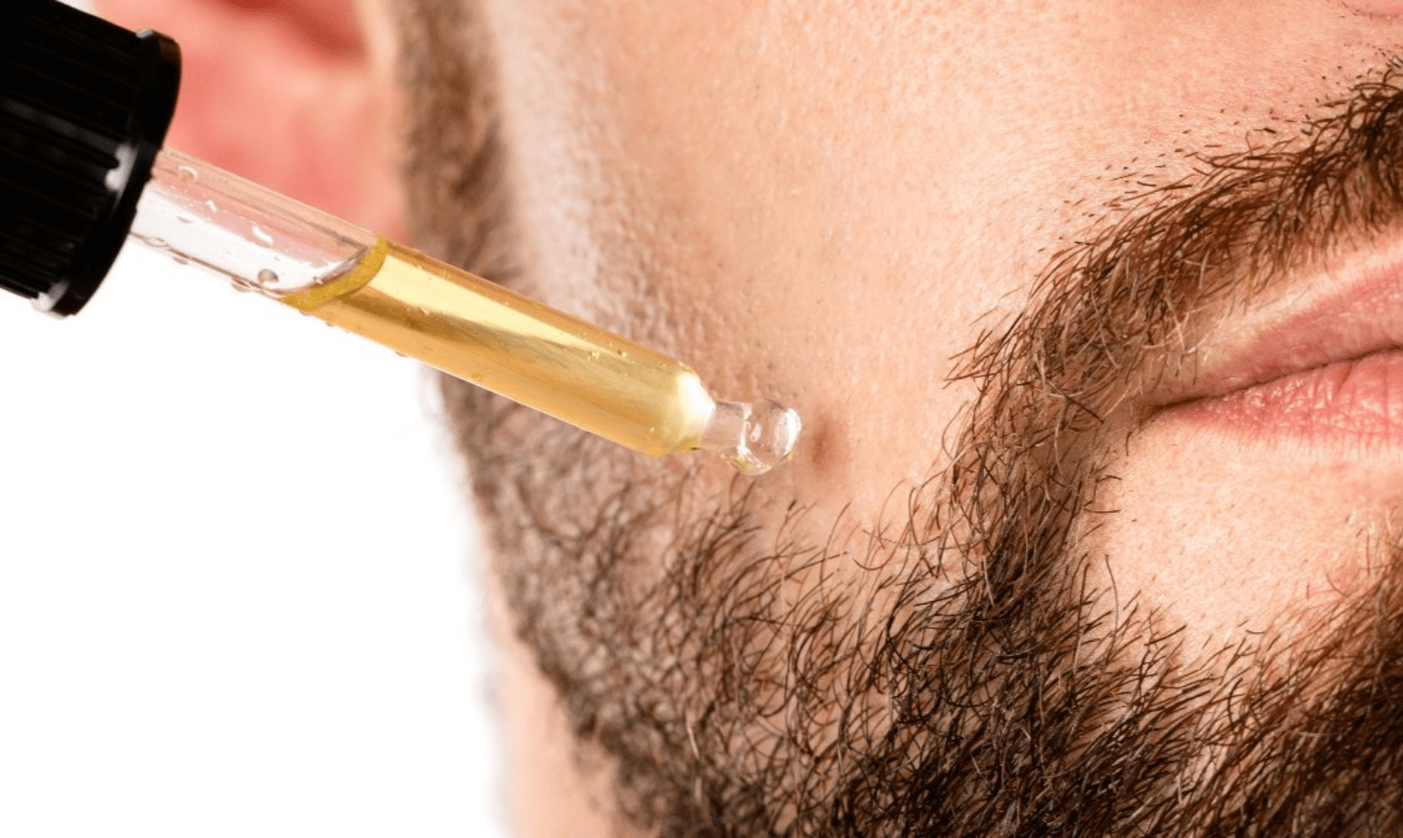 Hombre aplicándose aceite para la barba