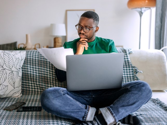 man sitting on couch reviewing the limits of liability insurance