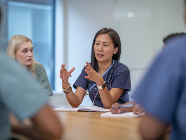 nurses in scrubs explaining nursing malpractice insurance