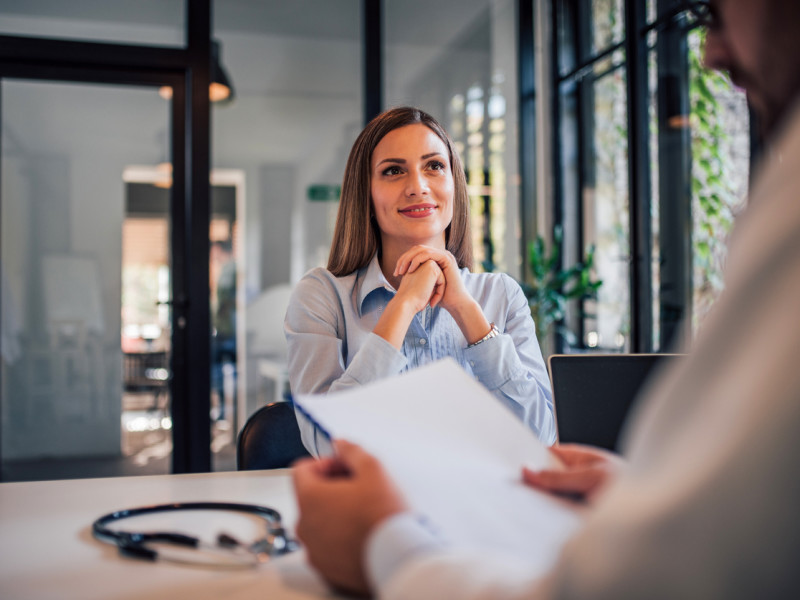 Blonde female nurse sitting in an interview with a male nurse hiring manager.