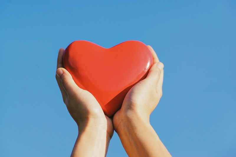 Hand holding a red wooden heart