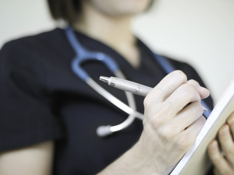 Nurse writing medication out for a patient.